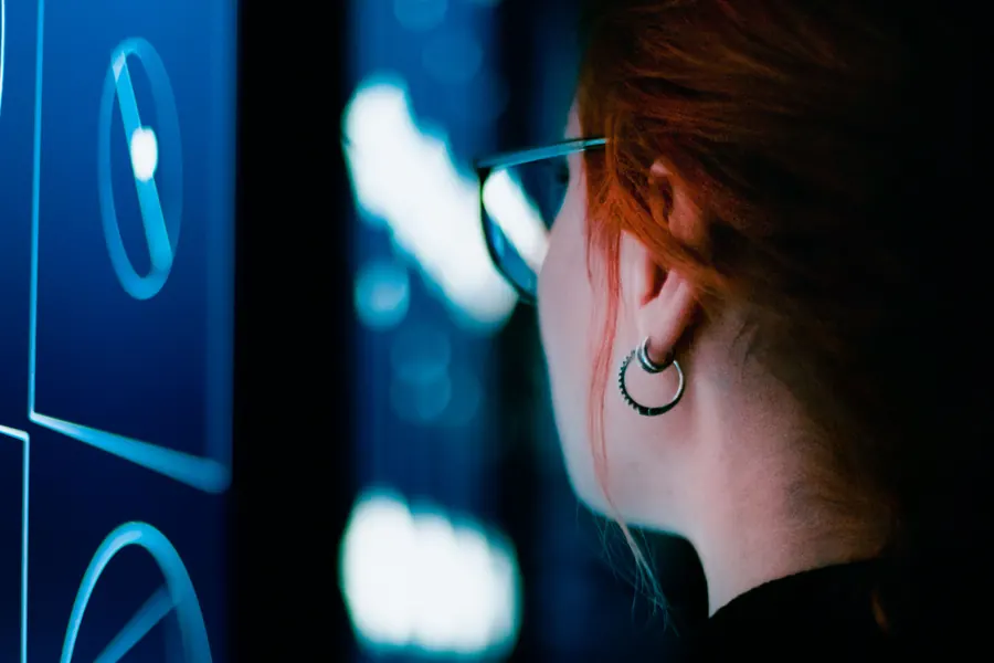 Woman monitoring illuminated server racks